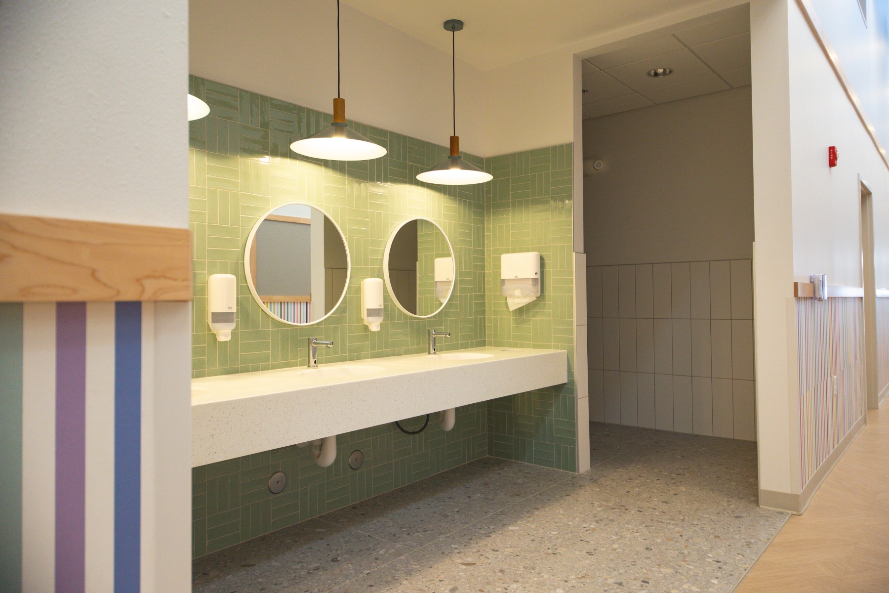 Modern restroom with double sinks and round mirrors