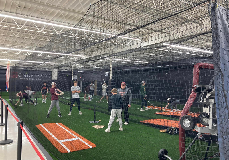 Kids practicing baseball in indoor batting cages